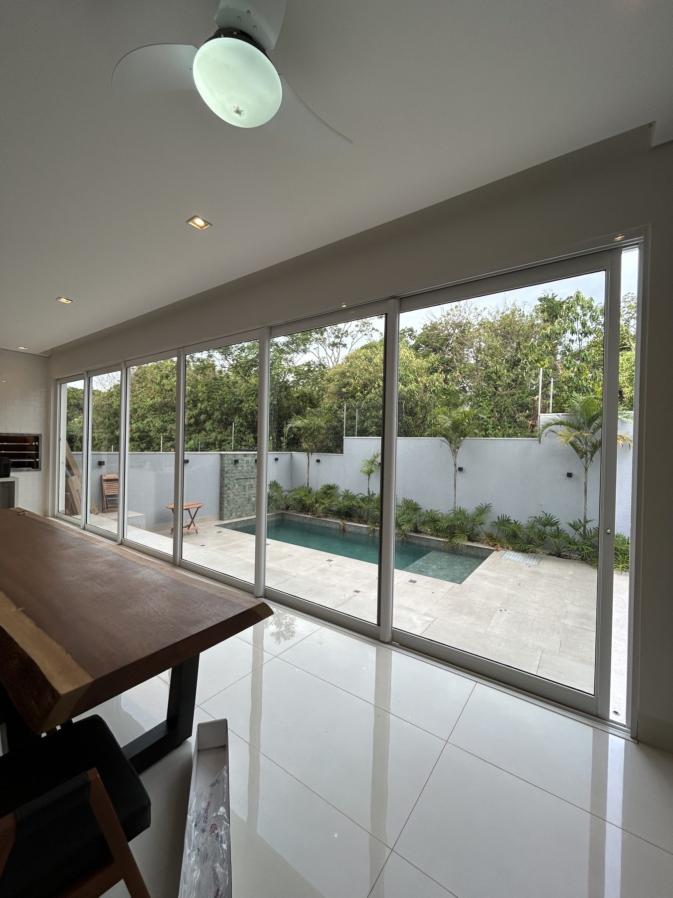Sala com portas de vidro e película, vista para a piscina